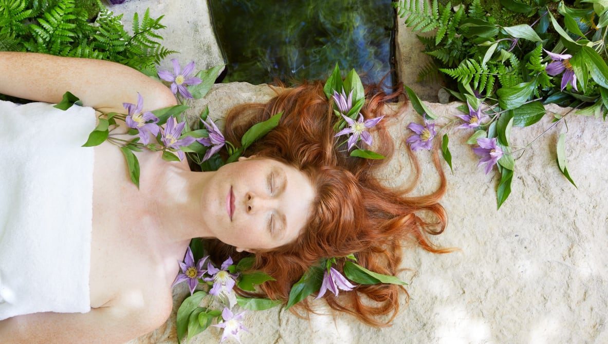 person relaxed with eyes closed and flowers around